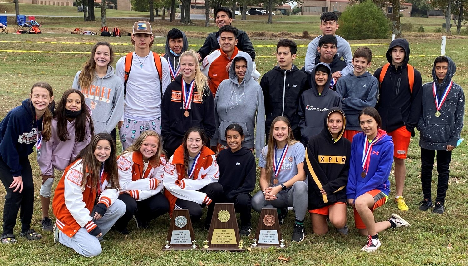 The Mineola girls varsity, boys varsity and girls junior high cross country teams pose with their trophies after placing first, third and second respectively at the district meet last Saturday. (Photo courtesy of TaShara Everett)